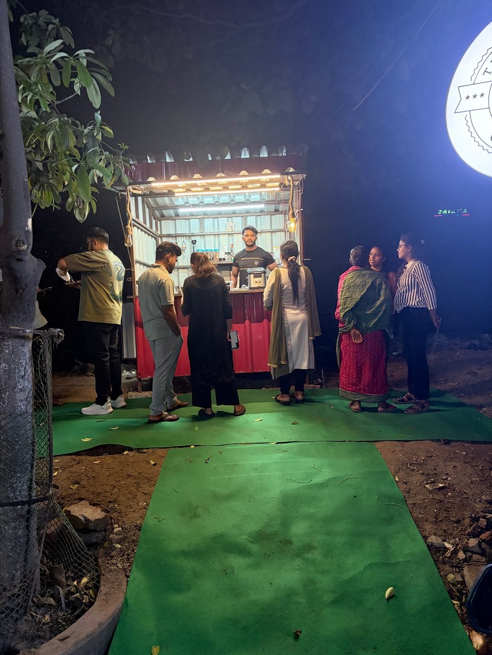 Customers lining up at a Bean Bar Coffee stall at night